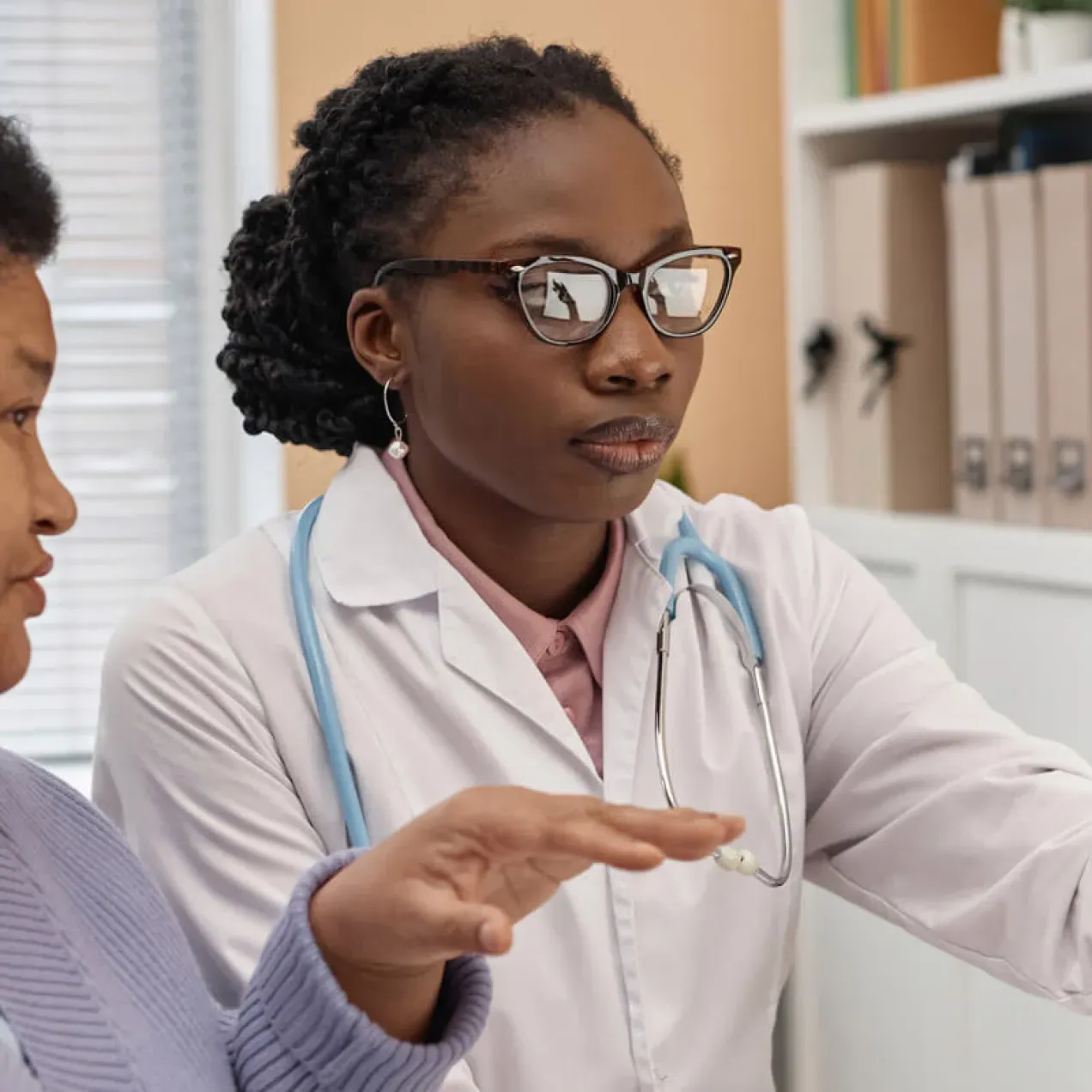 Primary care nurse practitioner with DNP reviewing treatment with patient